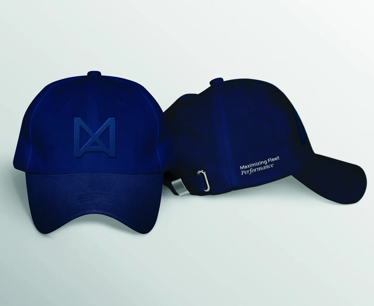 Two navy caps: one with a tone-on-tone embroidered logomark on the front, one with “Maximizing Fleet Performance” on the side.