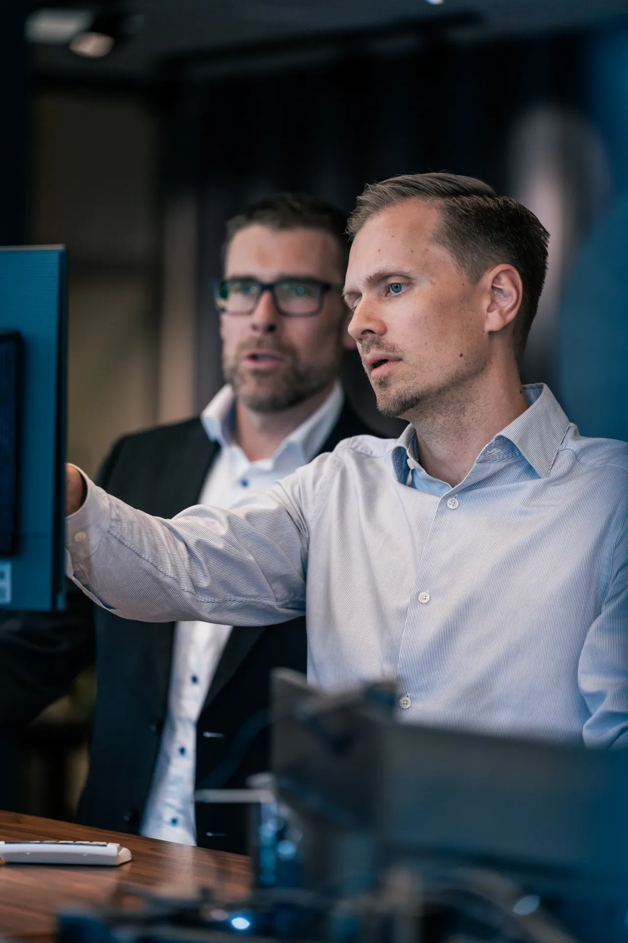 Two colleagues discussing details on a screen