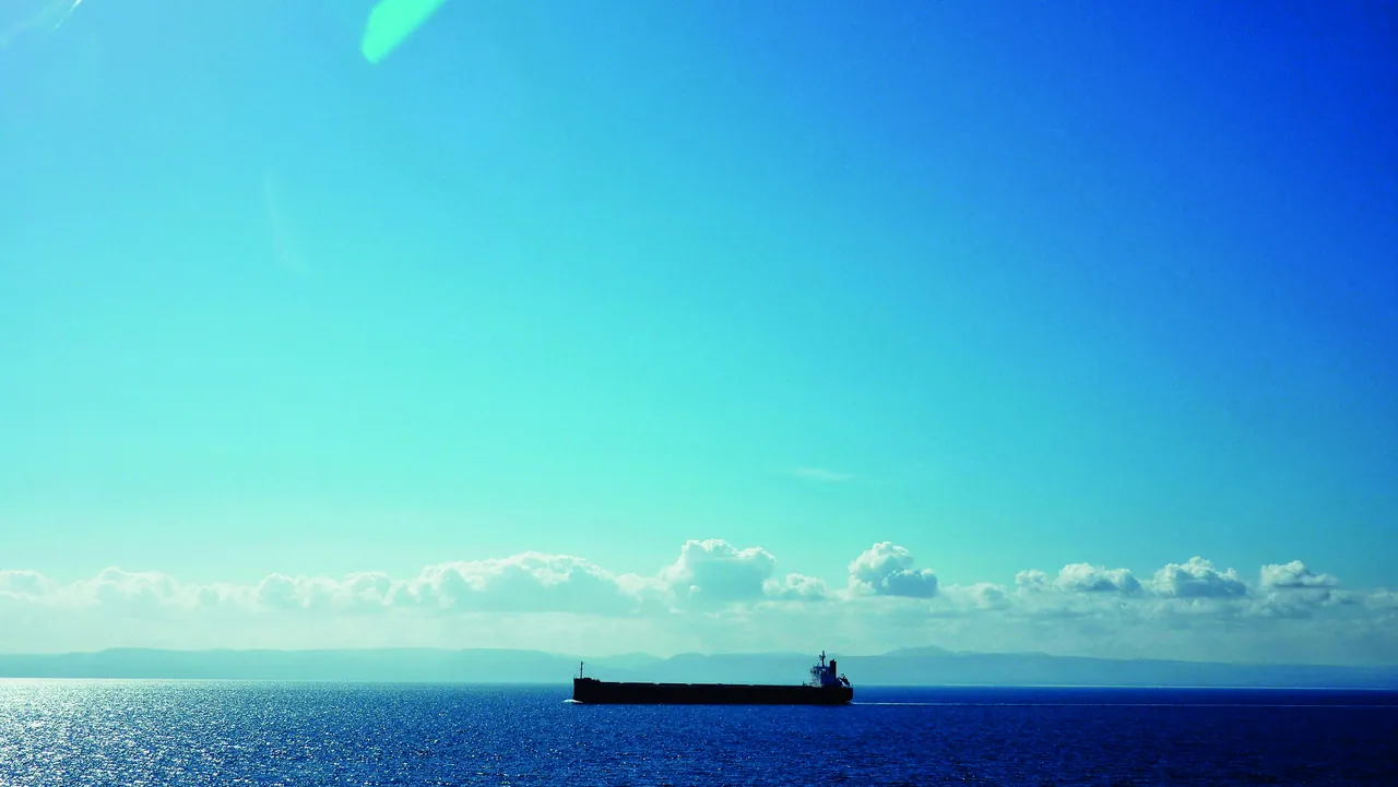 A tanker on the horizon under a bright sky
