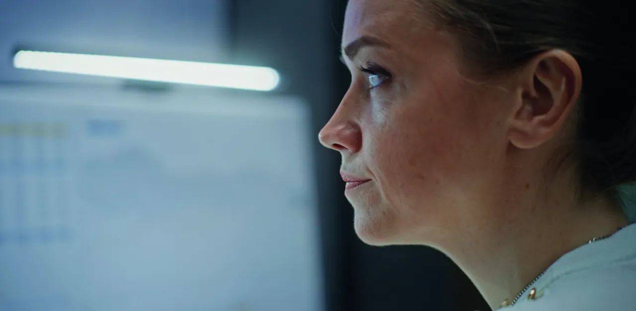 A woman in profile, concentrating on a screen